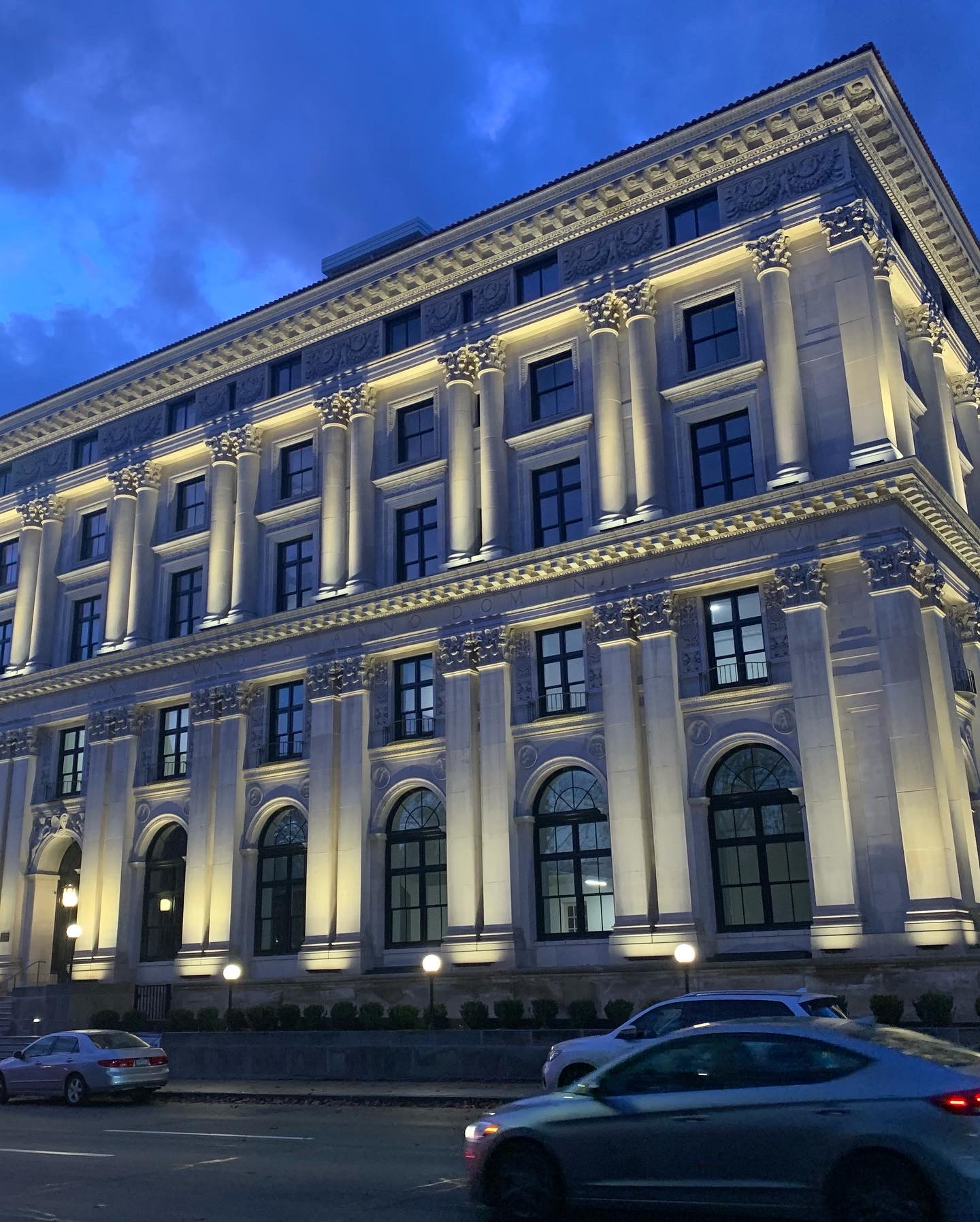 Pittsburgh Athletic Association building at dusk. Illuminated from below. 
                Cars passing across bottom on Fifth Avenue.